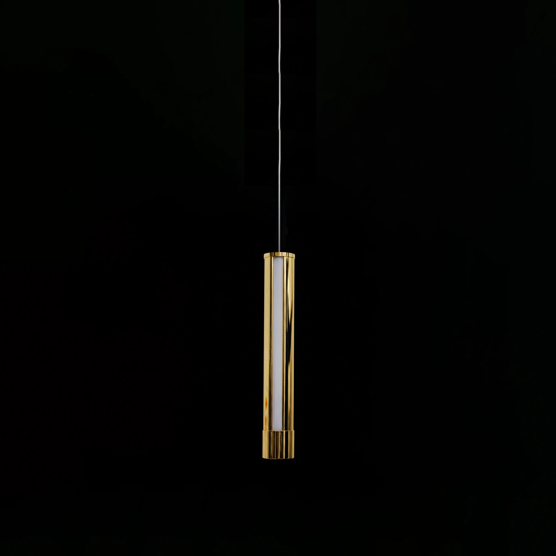 Gold cylindrical pendant light on a black background