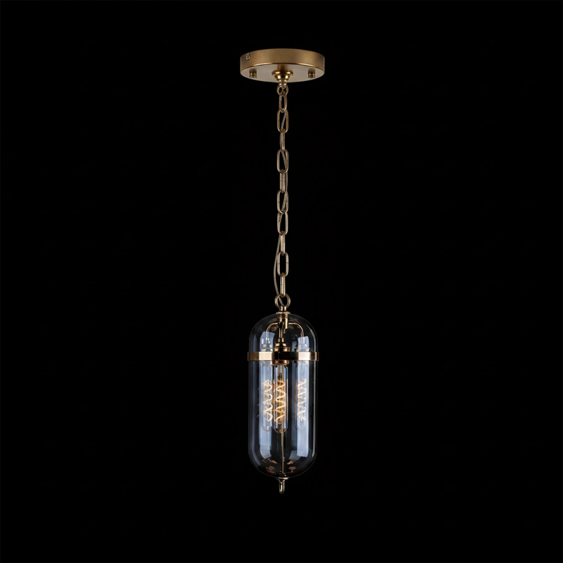 Pendant light with glass shade and brass accents on a black background